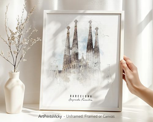 Framed artwork of the Sagrada Familia in Barcelona displayed on a table with a vase and hand.