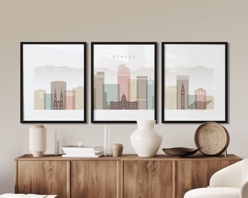 Three framed art prints of Denver's skyline with mountains in the background and various building silhouettes.