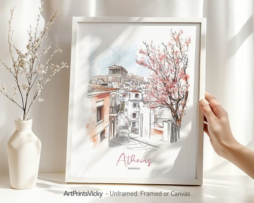 Hand holding a framed art print of Athens in watercolor drawing with soft pastel tones.
