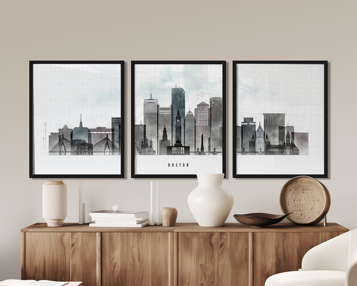Three framed art prints of Boston's skyline displayed on a wooden surface.