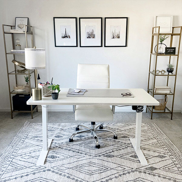 A modern office desk with a white chair and decorative items in a well-organized workspace.