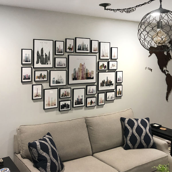 Wall display of framed cityscape prints featuring various famous buildings and landmarks.