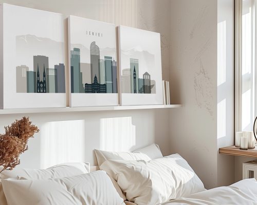 Three framed art prints of Denver's skyline displayed above a bed with white bedding.