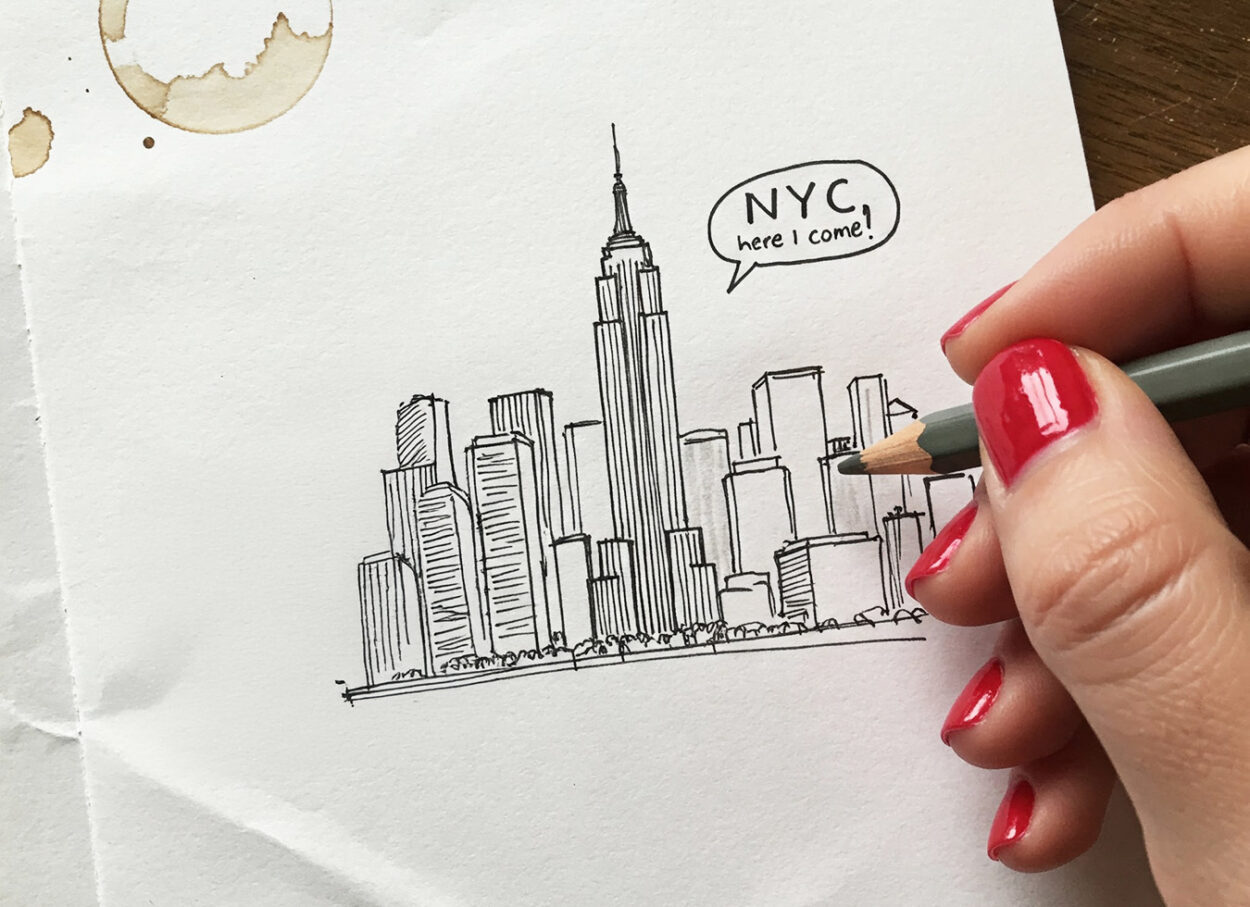 A hand-drawn sketch of the New York City skyline with the Empire State Building and a speech bubble saying 'NYC here I come!'