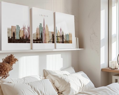 Three framed art prints of a London cityscape displayed on a shelf above a bed.