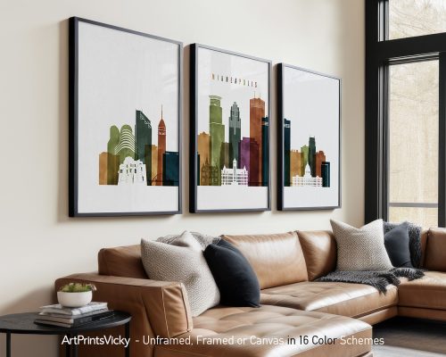 Three framed art prints of the Minneapolis skyline in various colors displayed on a wall.