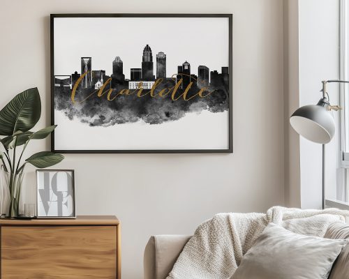 Framed artwork featuring the skyline of Charlotte with a black and gold color scheme.