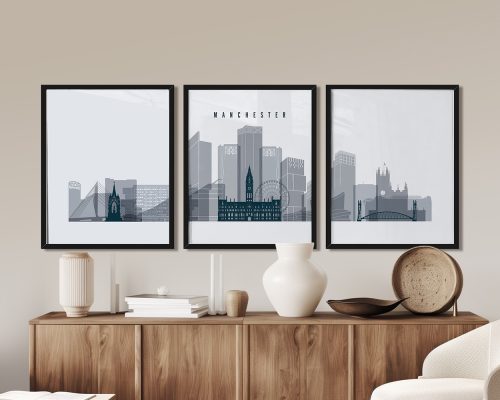Three framed art prints depicting a stylized cityscape of Manchester with notable buildings.