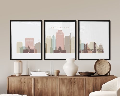 Three framed art prints depicting a stylized cityscape of Sacramento with buildings in various colors.