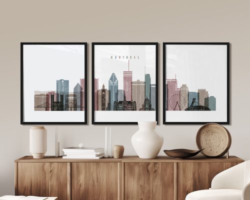 Three framed art prints of the Montreal city skyline displayed on a wooden surface.