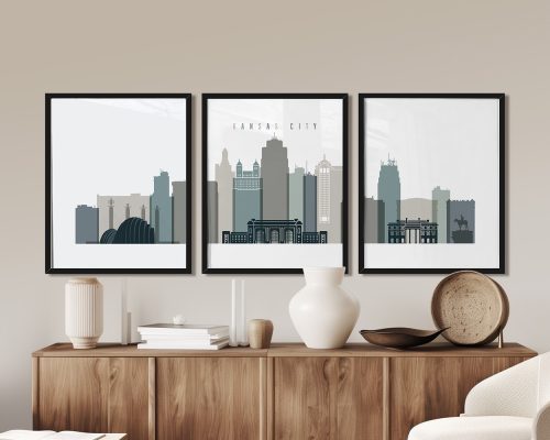 Three framed art prints of the Kansas City skyline displayed on a wall above a wooden sideboard.