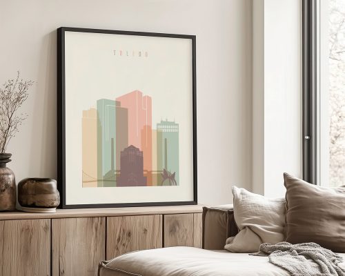 Framed artwork depicting a stylized cityscape of Toledo with pastel colors.