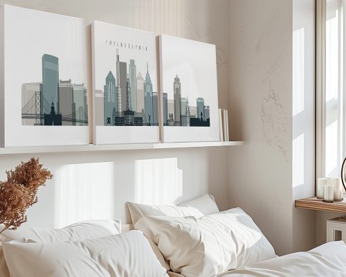 Three framed art prints of Philadelphia's skyline displayed on a shelf above a bed.