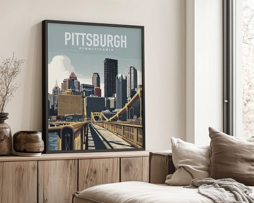 Framed artwork depicting a cityscape of Pittsburgh, Pennsylvania with buildings and a bridge.