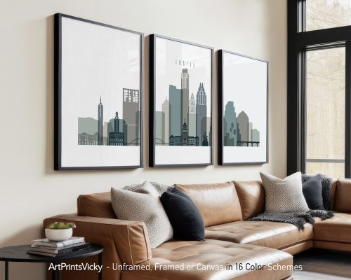 Three framed art prints of the Austin city skyline displayed on a wall above a couch.