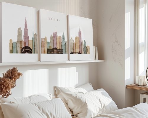 Three framed art prints of Chicago's skyline displayed on a shelf above a bed.