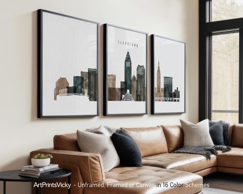 Three framed art prints of Cleveland's skyline displayed on a wall above a couch.