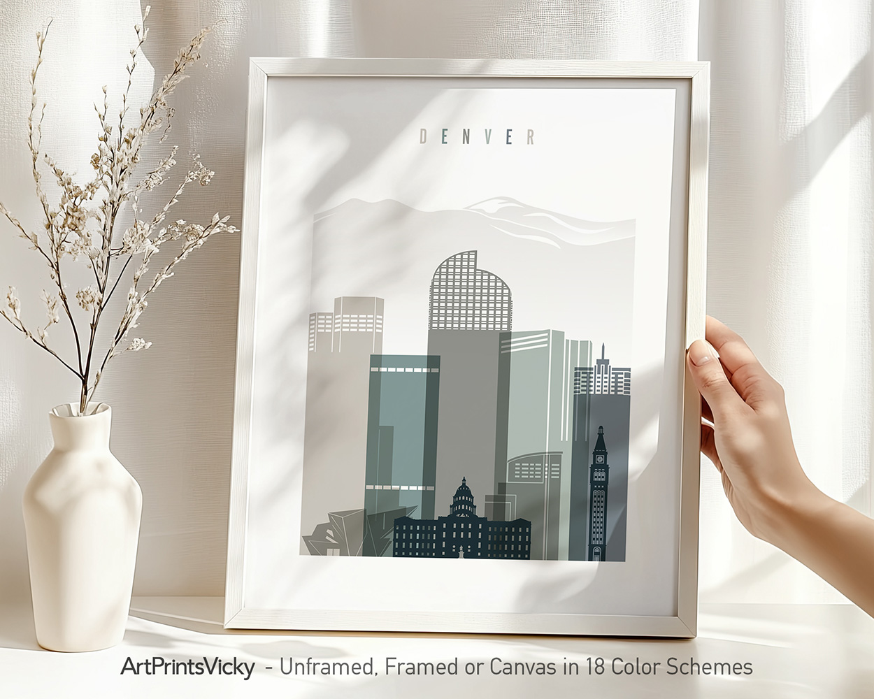Framed artwork depicting a stylized cityscape of Denver with various buildings and a light color palette.