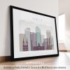 Framed artwork depicting a stylized cityscape of Denver with notable buildings and mountains in the background.