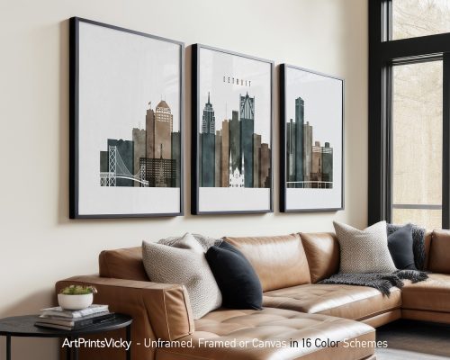 Three framed art prints of Detroit's skyline displayed on a wall above a couch.