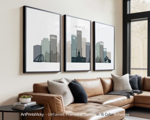Three framed art prints of Edmonton's city skyline displayed on a wall above a sofa.
