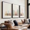 Three framed prints of Glasgow's cityscape displayed on a wall above a couch.