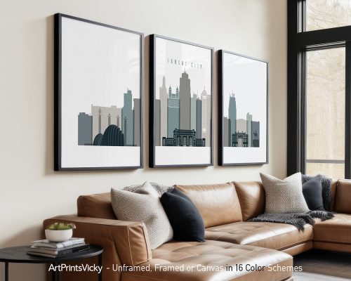 Three framed art prints of the Kansas City skyline displayed on a wall above a couch.