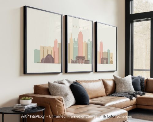 Three framed art prints of the Kansas City skyline displayed on a wall above a sofa.