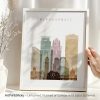Framed artwork depicting a stylized cityscape of Minneapolis with various building shapes and colors.