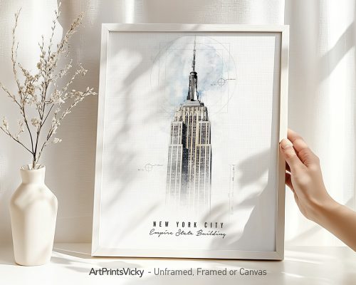 Art print of the Empire State Building framed and held by a hand with a vase in the background.