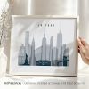 Framed artwork depicting the New York City skyline in shades of gray with notable buildings.