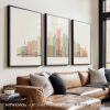 Three framed art prints depicting a stylized cityscape of Pittsburgh with buildings and a bridge.