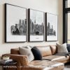 Three framed art prints of Tokyo cityscape displayed on a wall above a sofa.