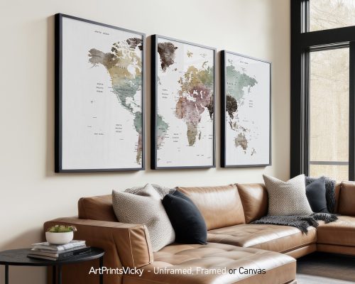 Three framed world maps with muted colors displayed on a wall above a sofa.