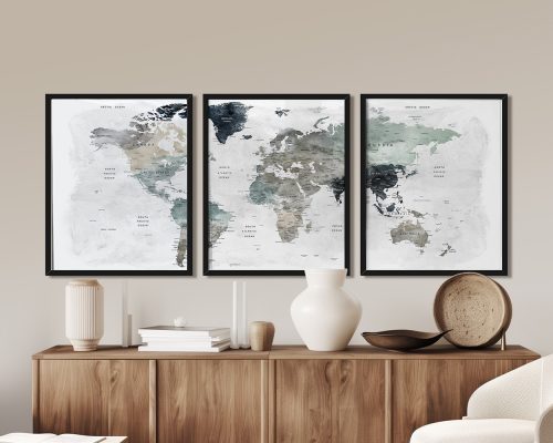 Three framed world maps displayed on a wooden surface with decorative items.