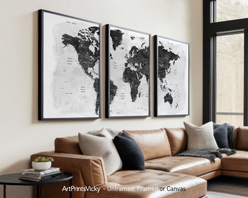Three framed black and white world maps displayed on a wall above a couch.